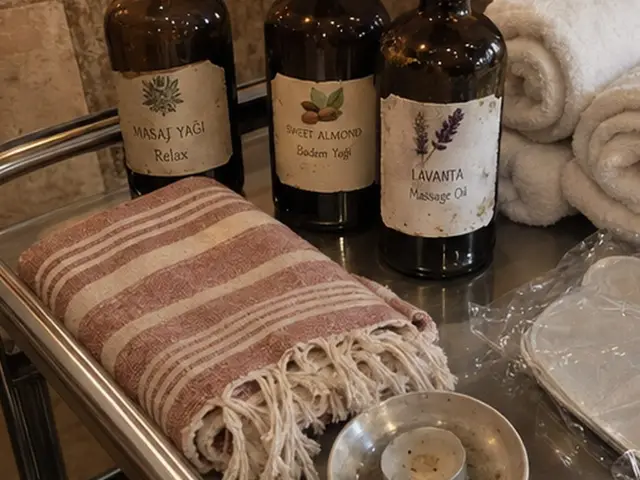 Masaj yağı şişeleri, rulo havlular ve pembe peştemal — Çobançeşme, Masaj Salonun